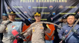 Polisi  menunjukkan celurit panjang dan stick golf yang dipakai para pelaku pembacokan dua supeltas di Kebraon, Kamis (25/5/2023).