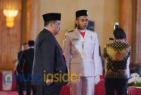Foto. Drs Achmad Dzulkarnaen, M.Si saat menerima Bendera Pusaka dari BPIP. 