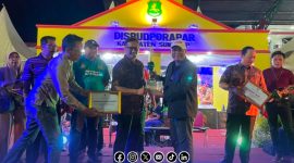 Foto. Kasubag Dinkes P2KB Sumenep, Nurul Syamsi,S.Kep.Ns., M.Kes saat menerima penghargaan mewakili Kepala Dinkes P2KB Drg Ellya Fardasah, M.Kes di Malam Penutupan Madura Night Vaganza 2025