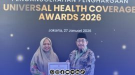 Foto. KH Imam Hasyim (Kanan) Bersama Drg Ellya Fardasah Kepala Dinkes P2KB Sumenep (Kiri) saat menerima penghargaan Nasional UHC